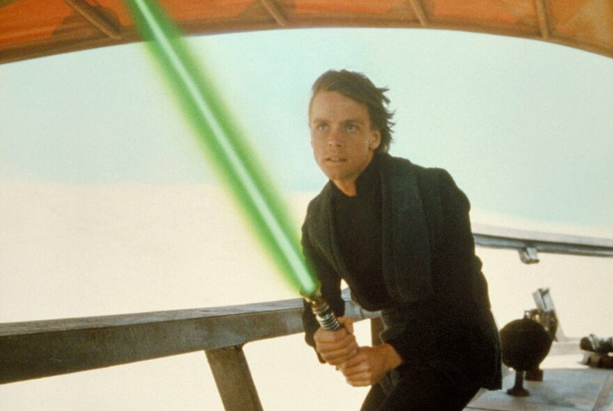 A scene showing Luke Skywalker holding a green light sabre from Star Wars: Return of the Jedi.