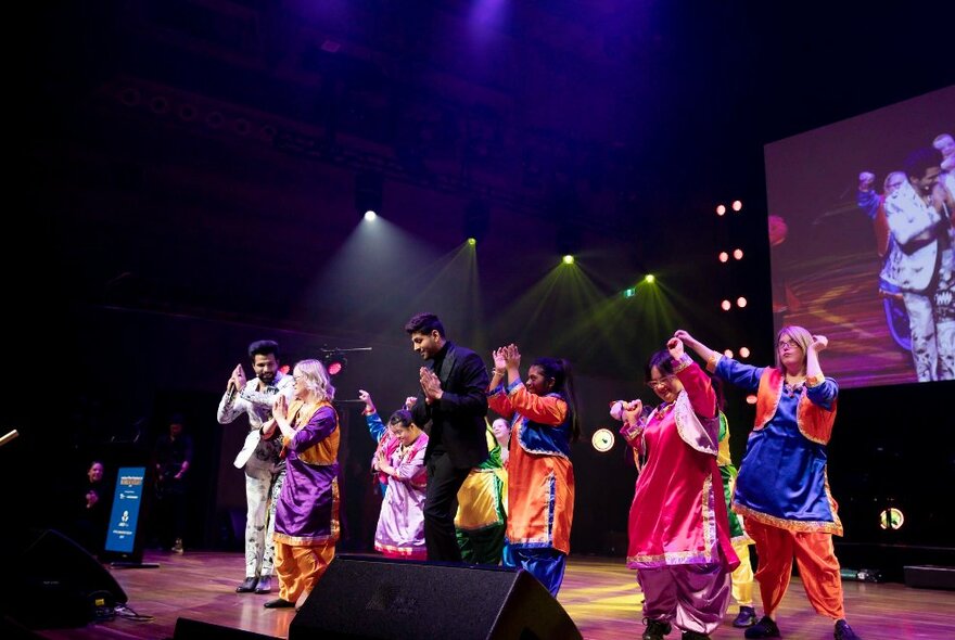 A live perfomance of people in traditional Indian attire. 