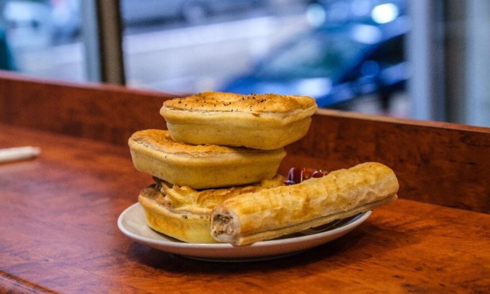 Plate with pies and sausage rolls on it.