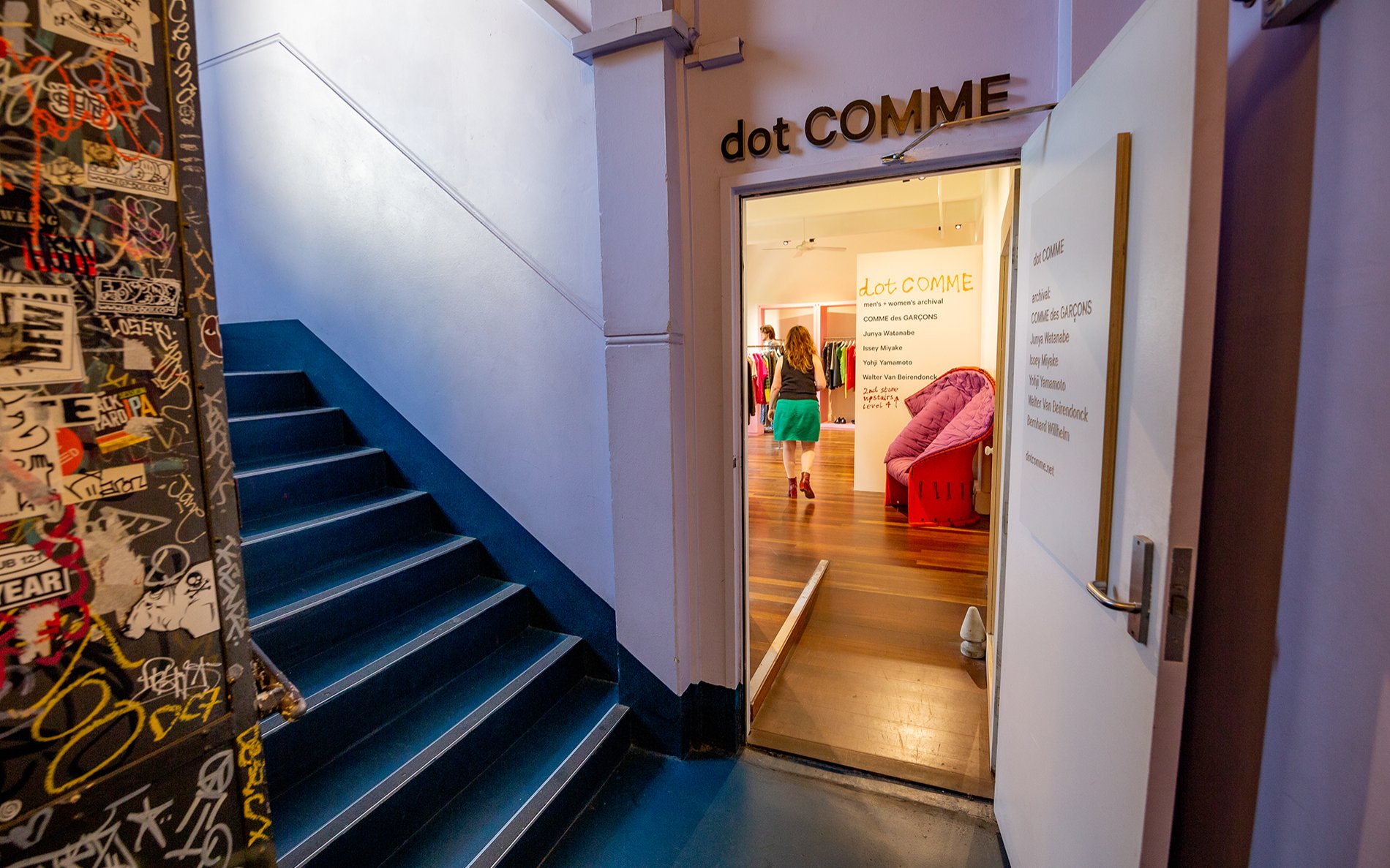 The entrance to a shop in a grungy staircase.