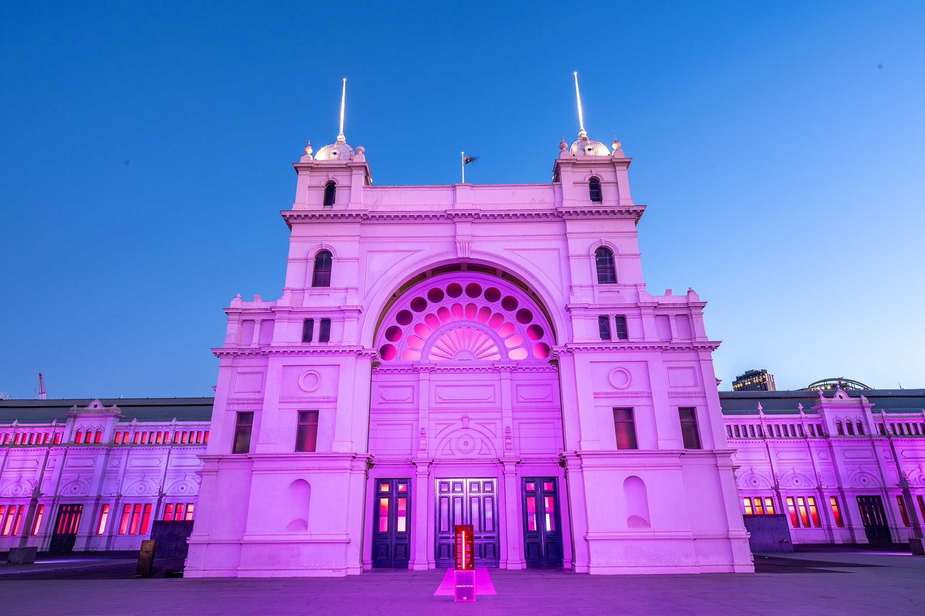 The Royal Exhibition Building lit up in pink lights.
