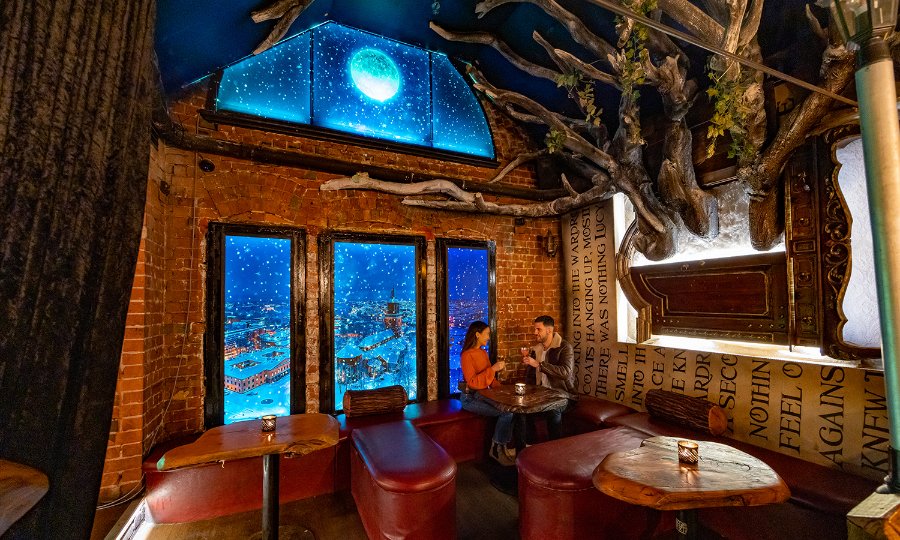 A couple in a fairytale themed bar.