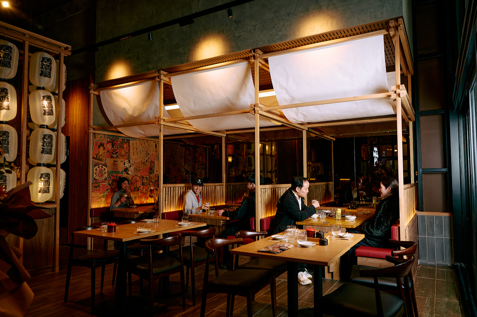 People dining in a Japanese restaurant with fabric draped overhead.