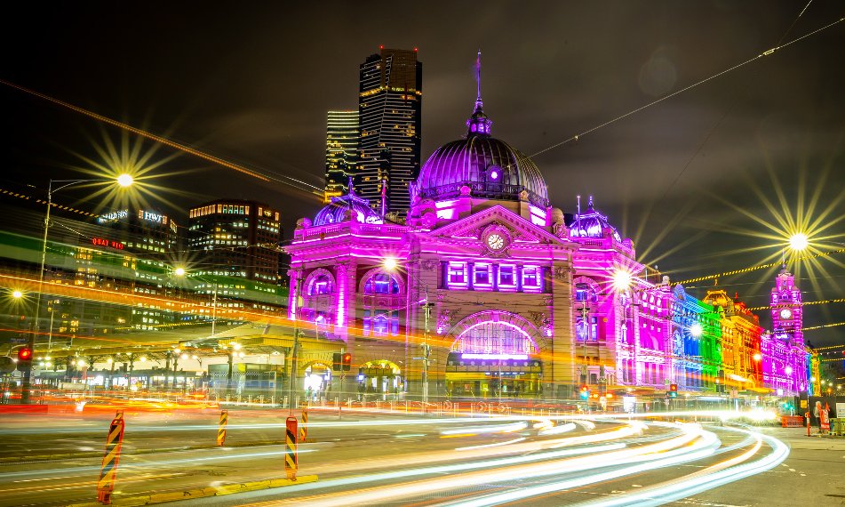Flinders Street Station lit up in rainbow colours.