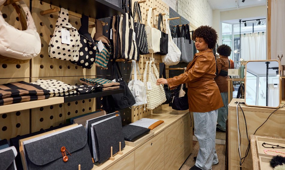 A woman is browsing bags in a store.