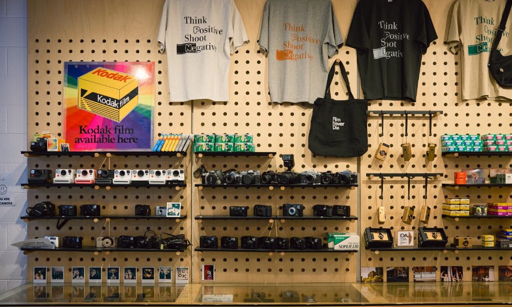 Peg wall with film, cameras and t-shirts.