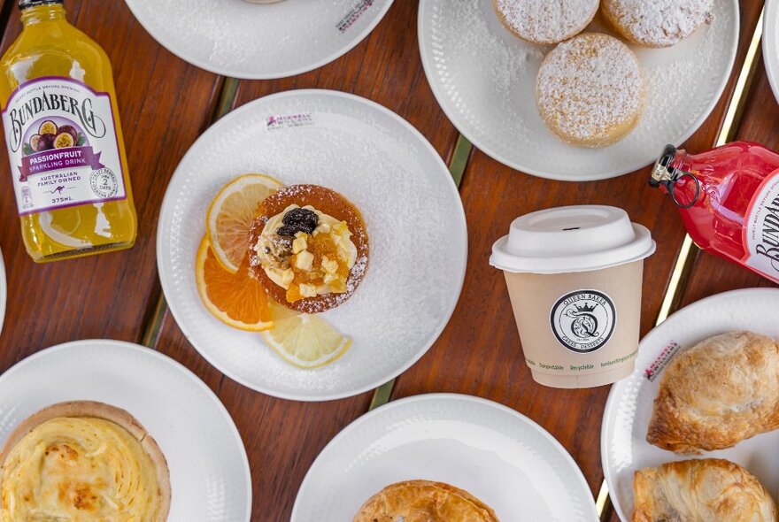 White plates with biscuits and pies and drinks.