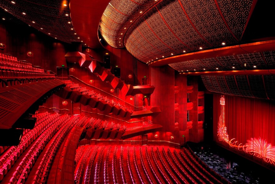 Tiered seating of the Ian Potter State Theatre and stage with majestic curtain featuring lyrebird’s tail.