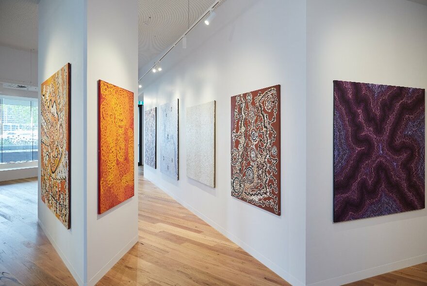 Inside an art gallery displaying large Indigenous paintings.