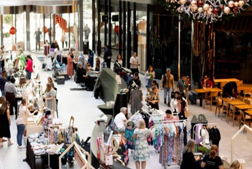 People browsing an indoor Christmas market.