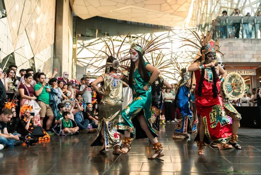 Day of the Dead dancers on stage with audience looking on.