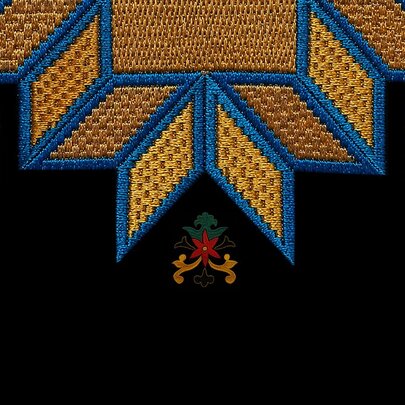 A close up of a hand embroidered handkerchief showing a yellow star with blue outline and small floral motifs on a black fabric.
