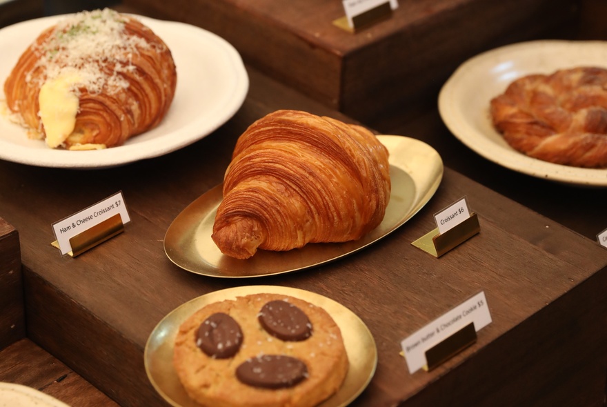 Freshly baked French pastries and cookies, on display on gold platters.