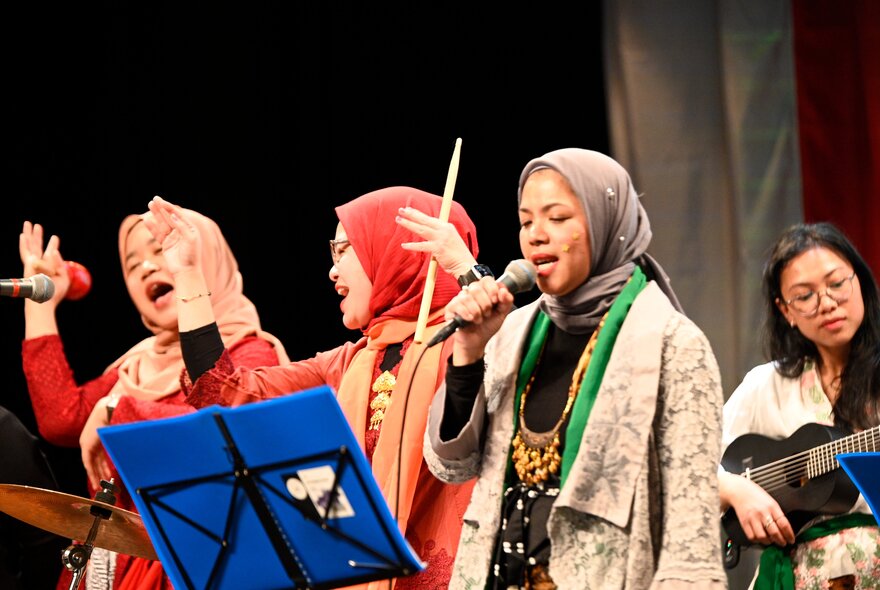 Indonesian musicians and singers performing with microphones.