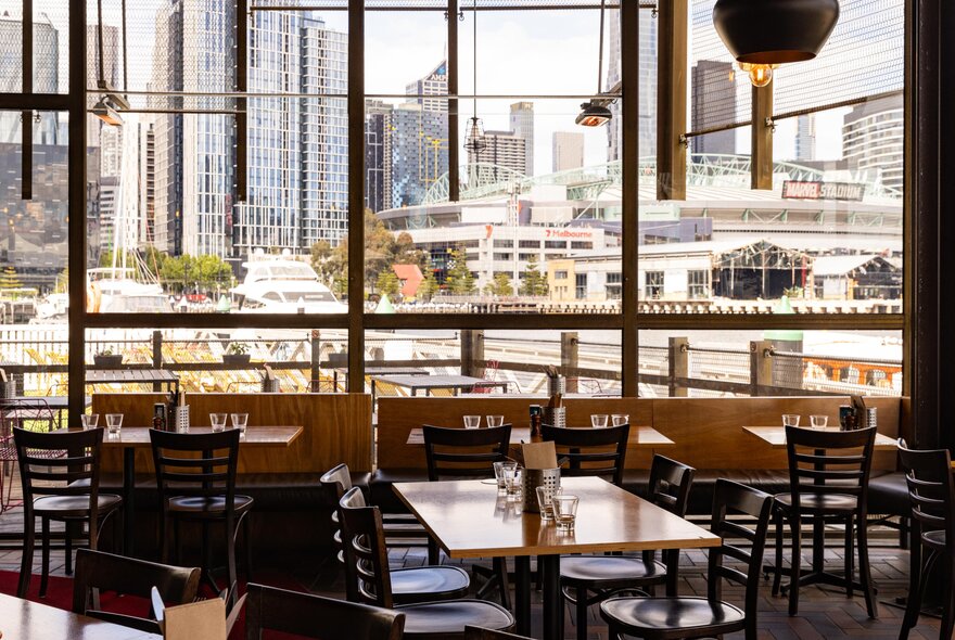 Interior of Cargo restaurant, with tables and chairs, and river and city views through the floor to ceiling windows.