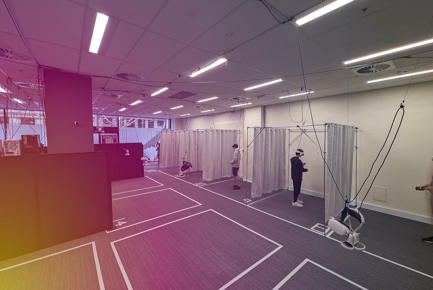 The inside of a virtual reality entertainment centre, with white squares marked out on the floor and individual curtained booths.