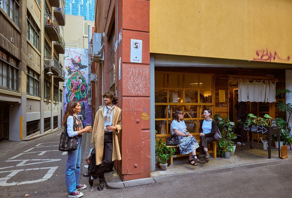 People hanging out outside a laneway cafe.