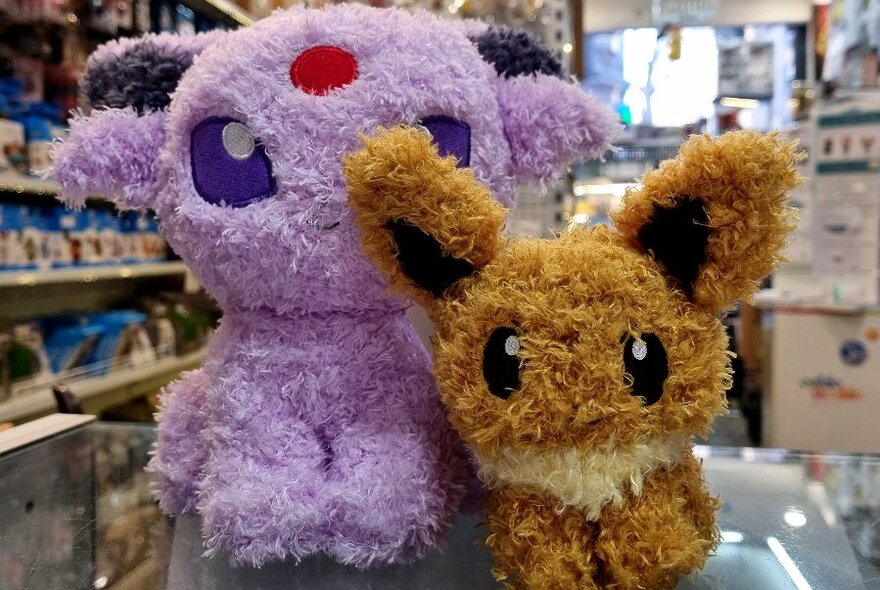 Two anime toys made from purple and brown fluffy fabric.