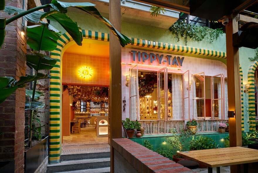 Entrance to Tippy-Tay showing green and gold tiled doorway and green plants.