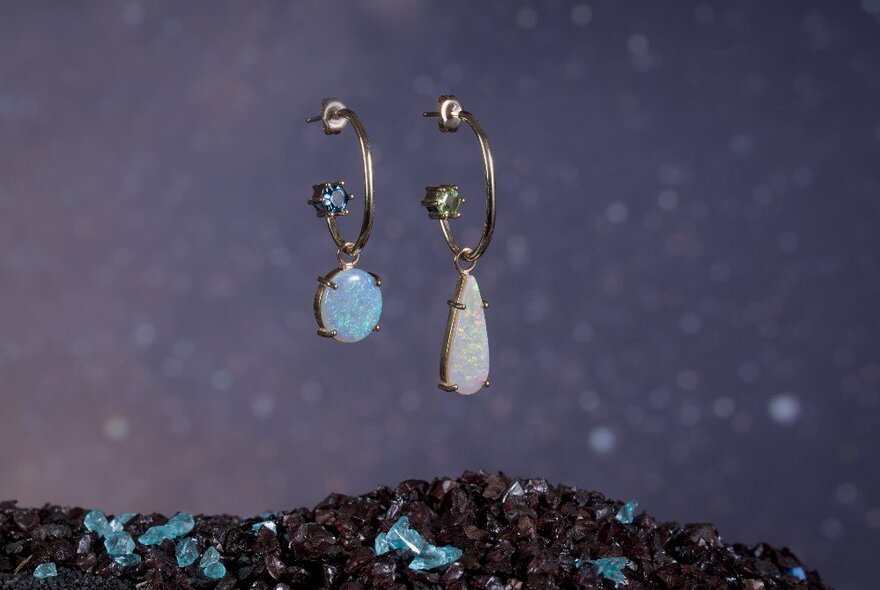 Two earrings each with a different coloured hanging opal.