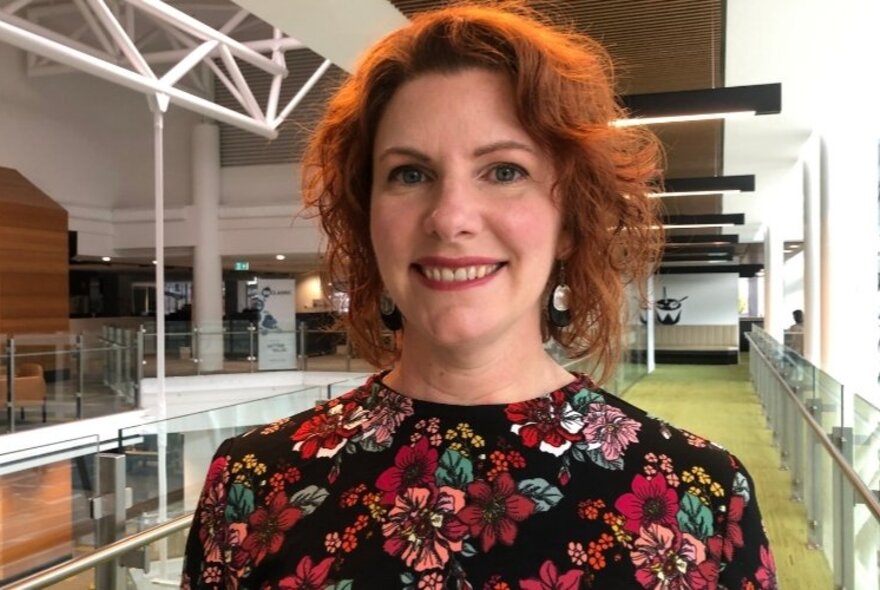 A smiling Sarah L’Estrange in a floral top