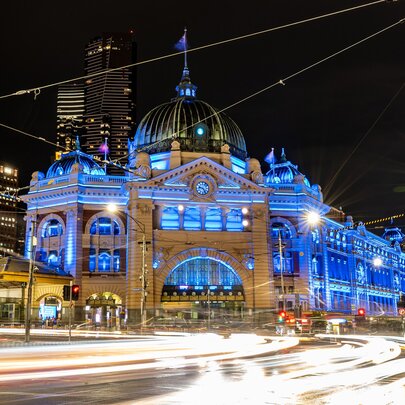 Flinders street station lit up in blue lights at night