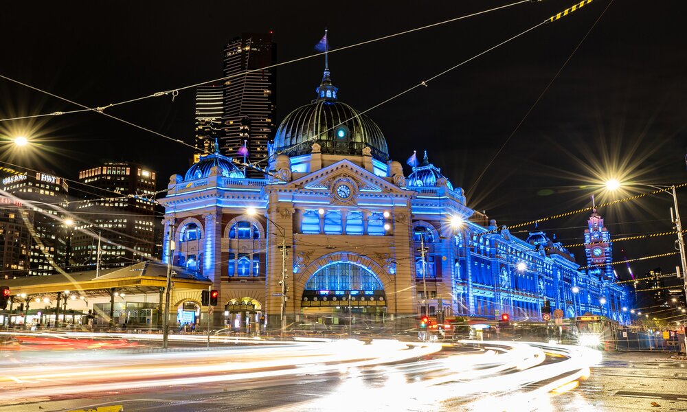 Flinders street station lit up in blue lights at night