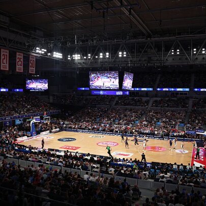 A National Basketball League match underway inside John Cain Arena at Melbourne Park, with an indoor court and spectators watching from the stadium seats.