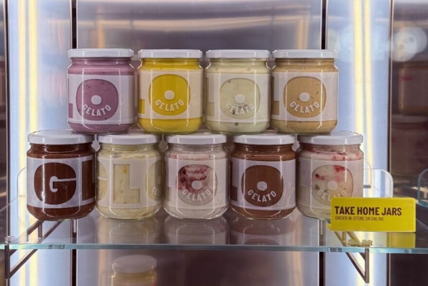 A shelf with take home jars of gelato. 