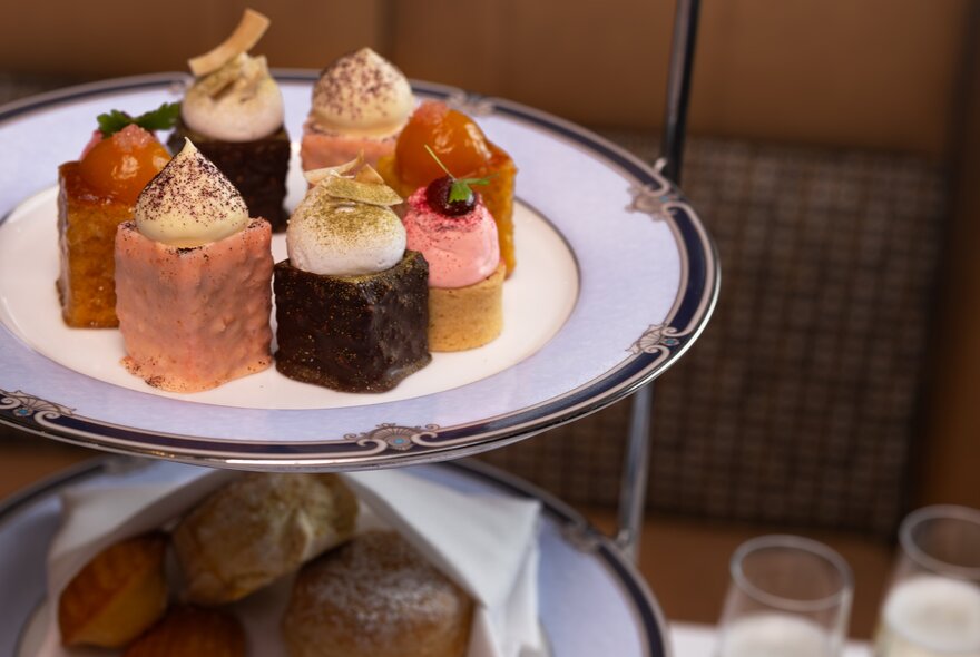 A high tea experience featuring a tiered stand filled with pastries and savoury bites.
