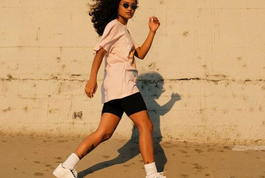 A woman in bike shorts and a pink t shirt. 