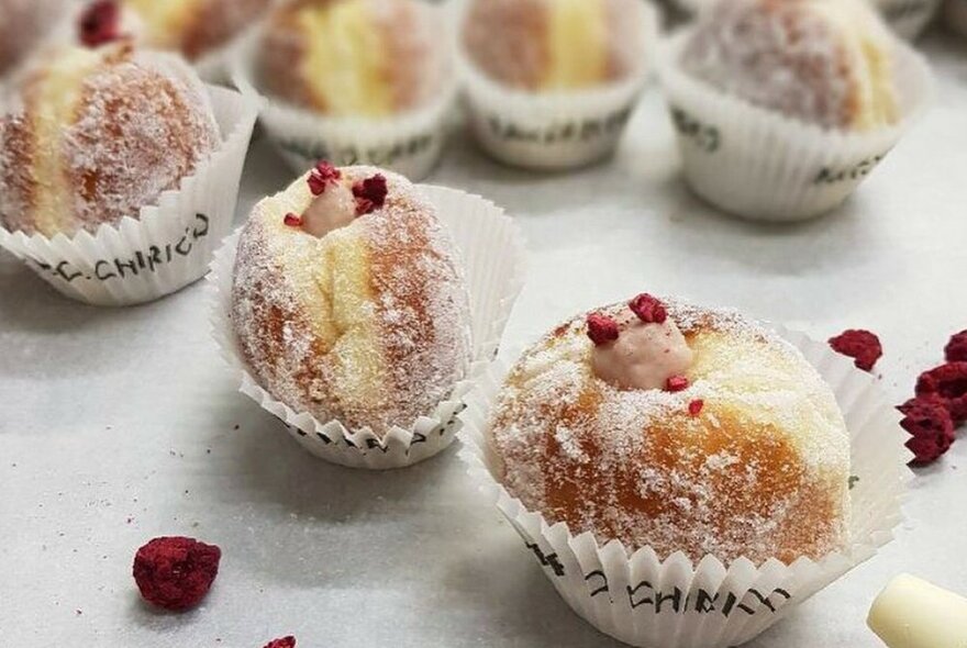 White tray of filled doughnuts.