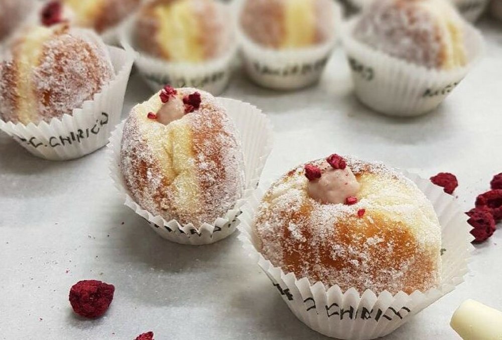 White tray of filled doughnuts.
