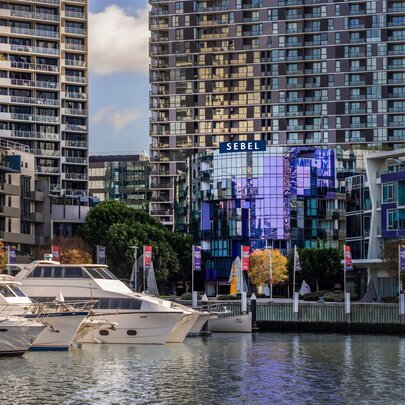 Looking across the Yarra River at the Sebel Hotel Docklands, boats moored to the left. 