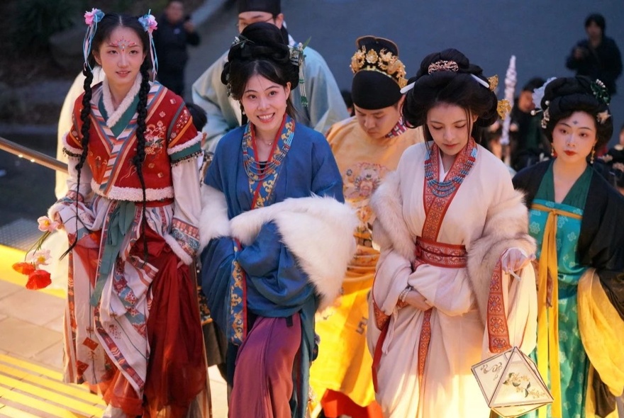 A group of women in traditional Chinese costumes of various colours.