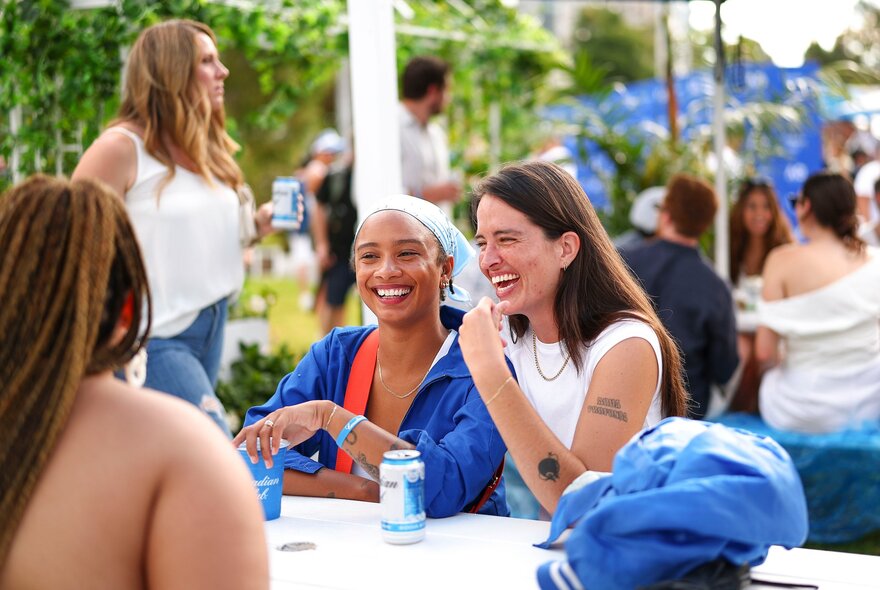 Women laughing and enjoying each other's company at an outdoor table 