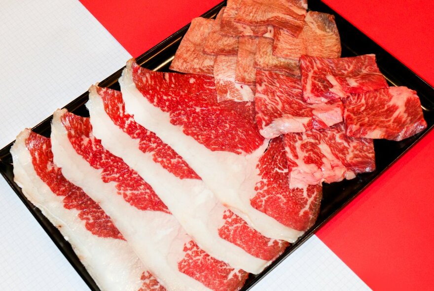 Wagyu beef slices in a black tray.