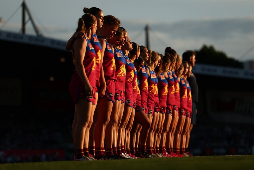Brisbane Lions AFLW team lined up in the sunset.
