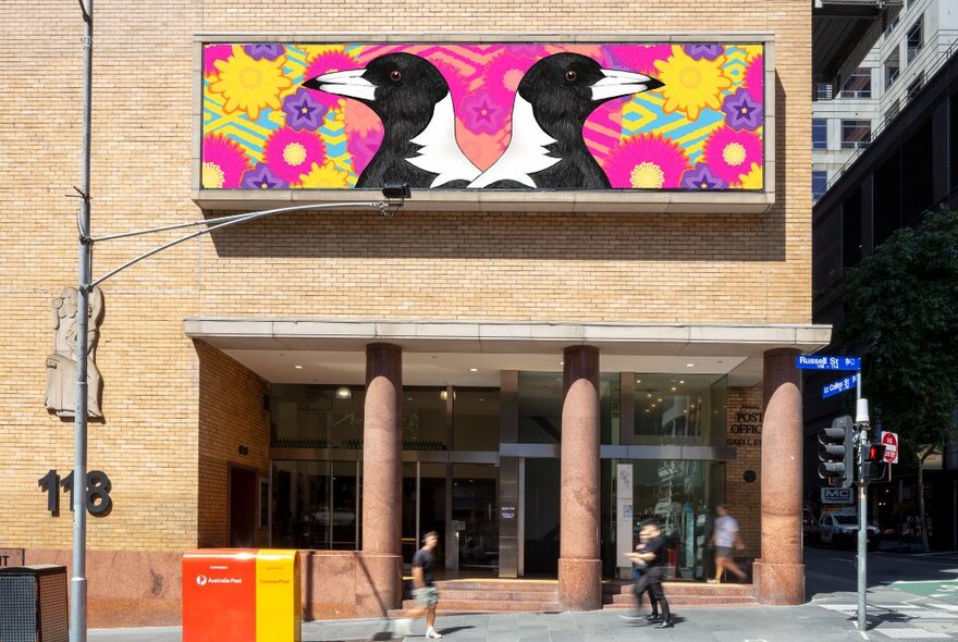 Brightly coloured artwork on the facade of the Hero apartment building, featuring magpies and flora.