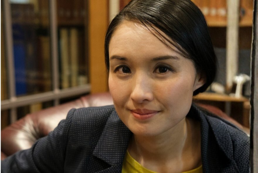 Author Alice Pung, with a slight smile, her straight dark hair is pulled back off her face.
