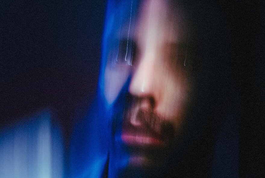 A dark and blurry image of a man's face.