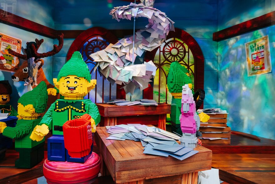 A Christmas scene of elves in Santa's study, all made from LEGO.