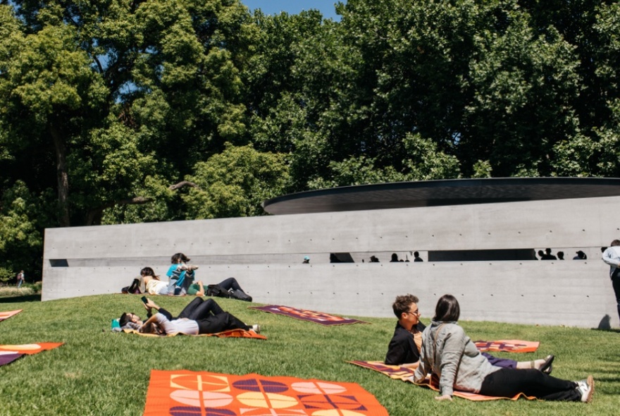 People relaxing on the lawn outside MPavillion. 