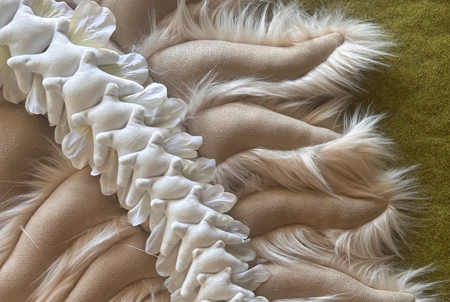 A sculptural artpiece made from fabric that represents a spine and ribs or lungs.