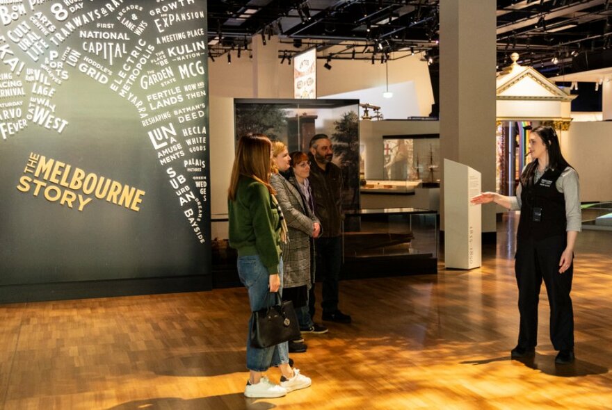 Tour participants listening to a museum guide as she leads them through a gallery at the Melbourne Museum.