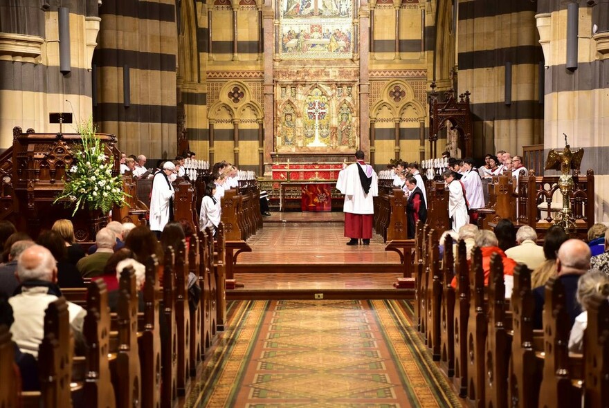 Choir and worshippers inside the neo-Gothic St Paul's Cathedral building.