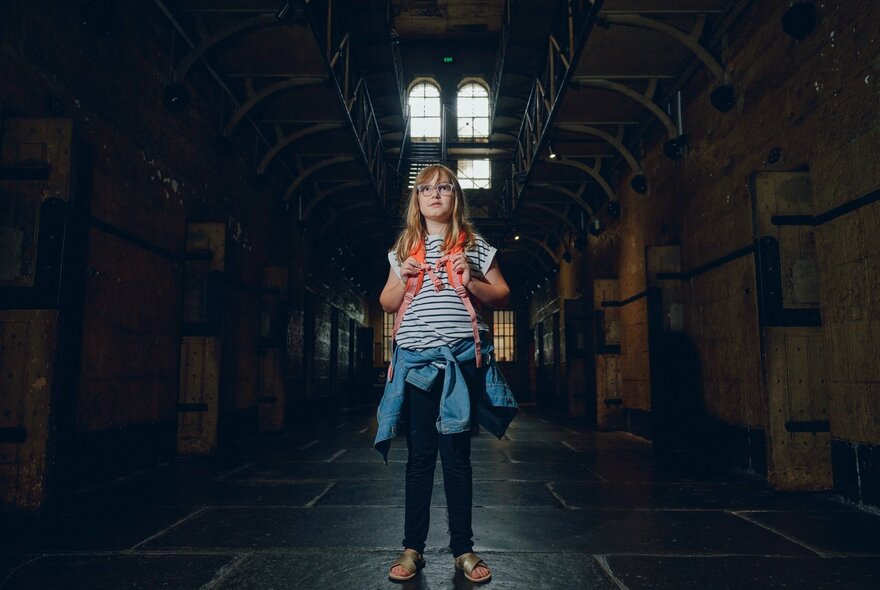 A young girl standing in a corridor of the Old Melbourne Gaol.