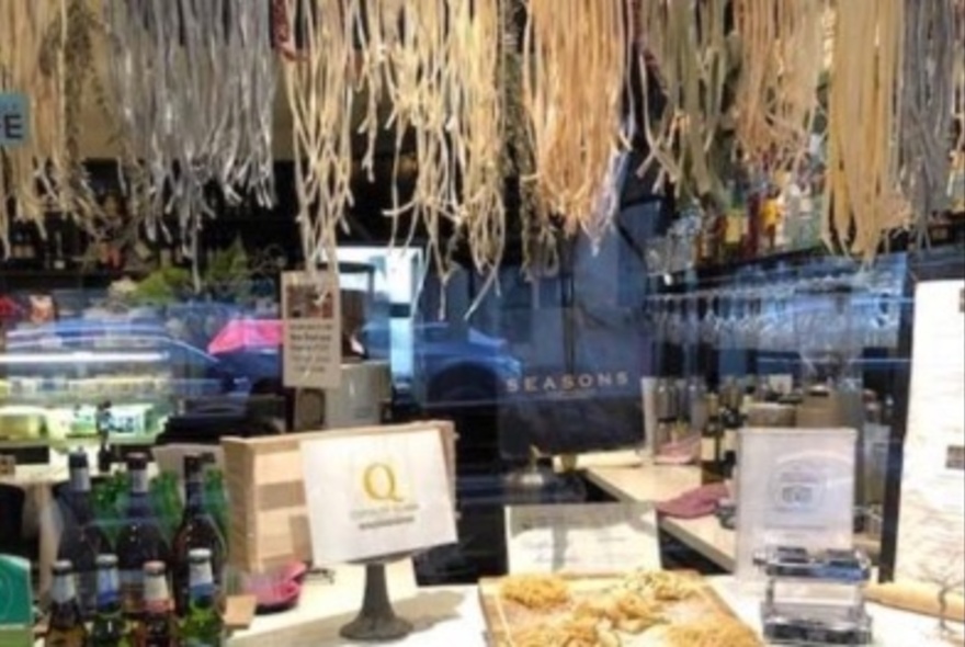 Shop interior with hanging pasta up top.