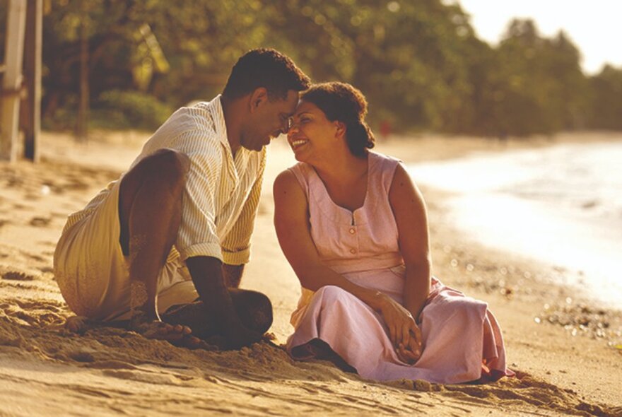 Still from the film 'Mabo' of two actors sitting on a beach, their heads close together with foreheads touching.
