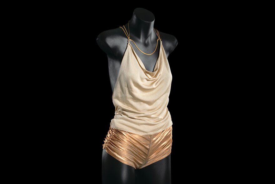 A black mannequin displaying the gold hot pants and halter top worn by Kylie Minogue in her famous music video, Spinning Around.